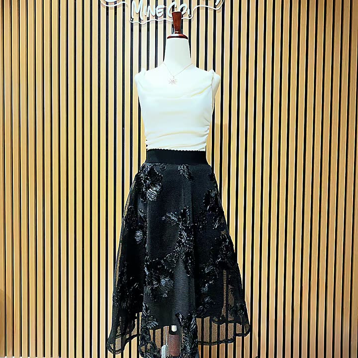 Black embroidered organza midi skirt on a hanger and styled on a form with an ivory sleeveless top