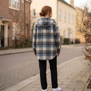 Rear view of a model wearing the slate blue and oatmeal check shacket outdoors