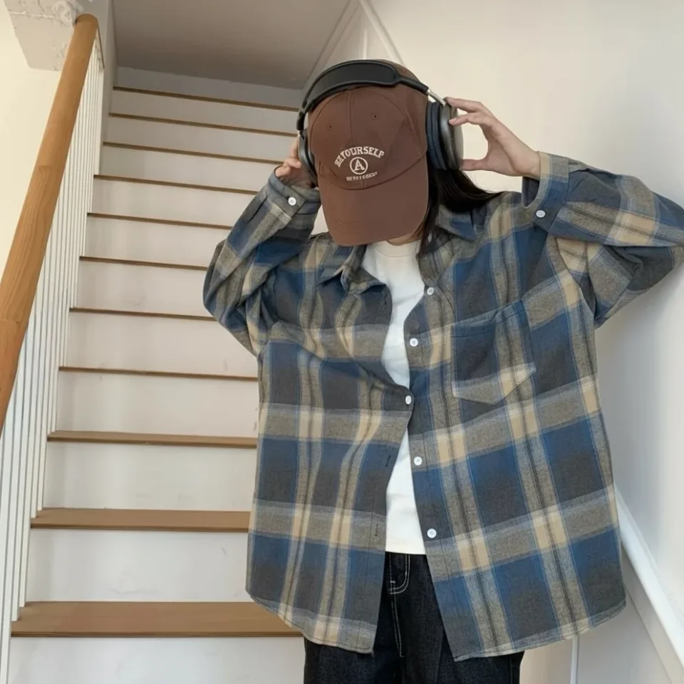 Woman wearing an oversized blue check overshirt over a white tee