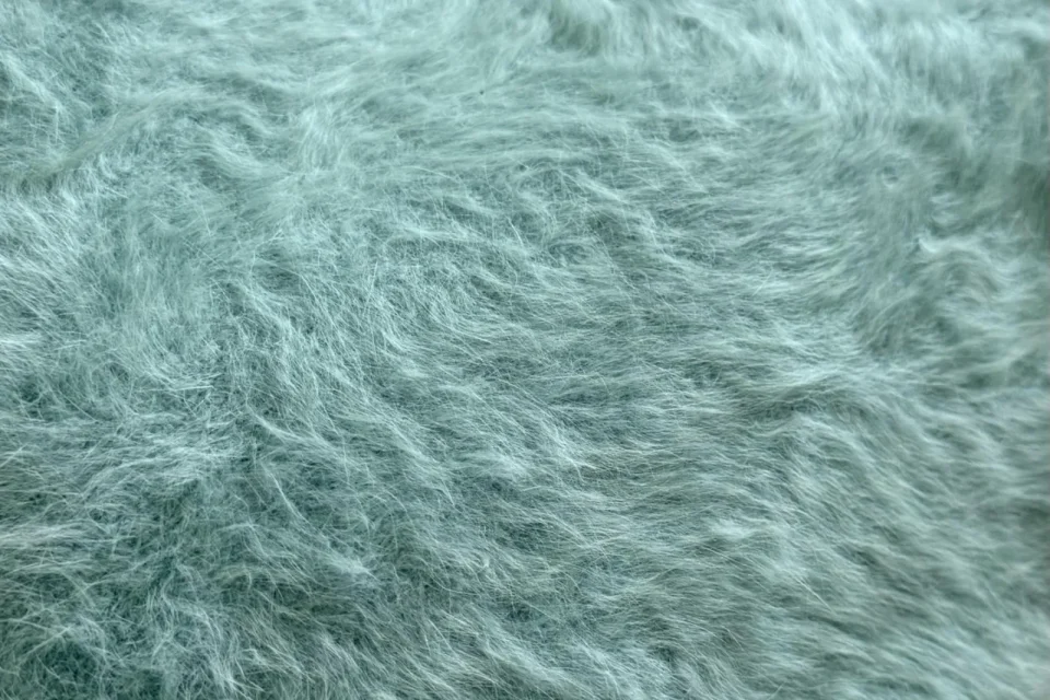 A close-up of soft mint-green faux fur
