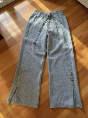 Wide-Leg Knit Trousers with Button Slits — Soft knit wide-leg trousers with side slits and three contrast buttons at the