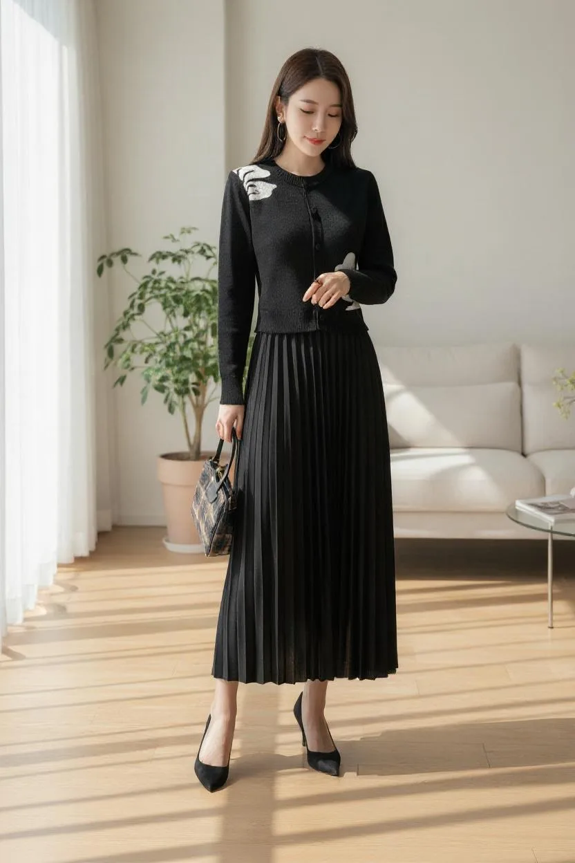 Heritage Crest Knit Dress — A fine-ribbed column dress in black or grey, with an embroidered crest at the shoulder and a