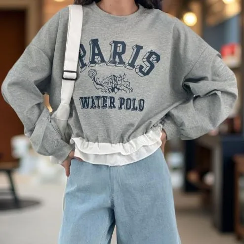 Ruffle Hem Graphic Sweatshirt Ruffle Hem Graphic Sweatshirt — A slightly cropped sweatshirt with a PARIS WATER POLO collegiate graphic and a contrasti