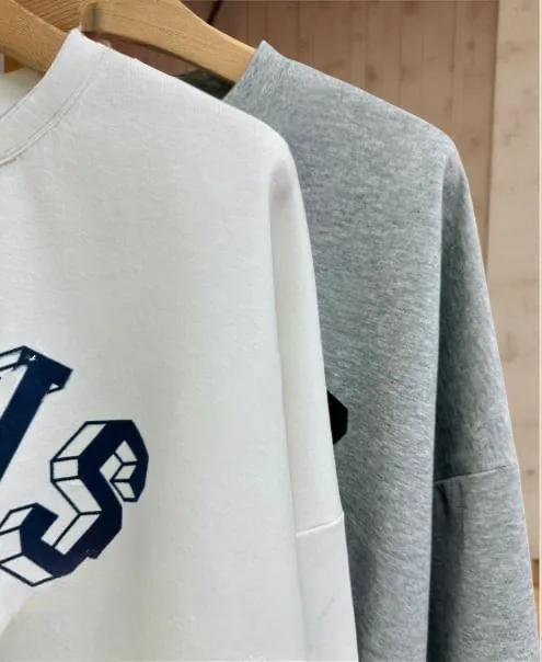 Ruffle Hem Graphic Sweatshirt — A slightly cropped sweatshirt with a PARIS WATER POLO collegiate graphic and a contrasti