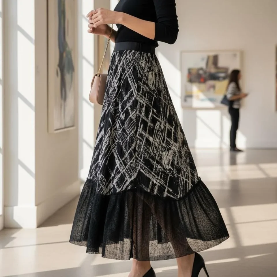 Abstract Pleated Statement Skirt — A black pleated midi with a white architectural scratch print and a sheer black hem p