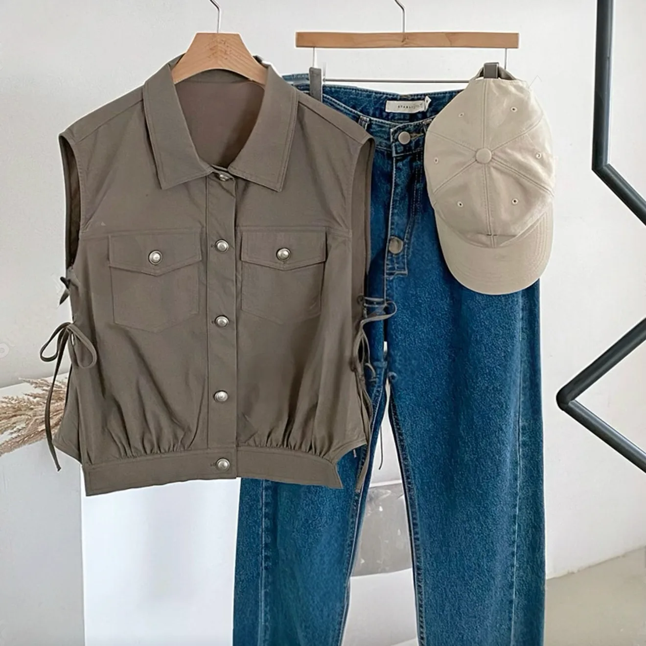 Cropped Utility Tie-Side Vest Cropped Utility Tie-Side Vest — A cropped sleeveless shirt-jacket in washed olive, with chest pockets and lace-up ties a