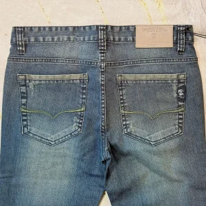Washed Denim Jeans — Mid-blue washed denim in a straight cut, faded through the thigh and seat. Button fly, natural wais