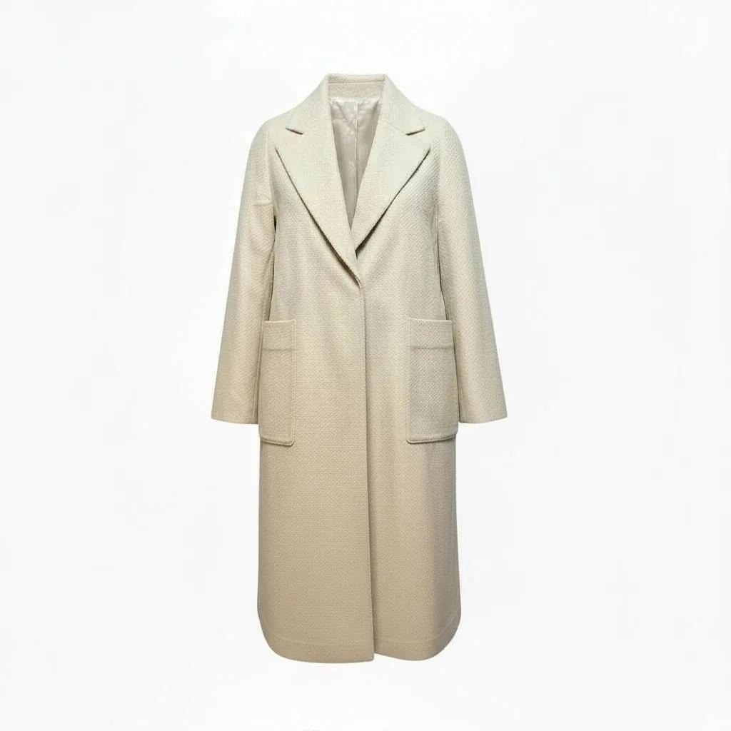 Wool-Blend Long Coat Wool-Blend Long Coat — A long, collarless wool-blend coat with a clean front and no belt. Cream, lined to the hem.